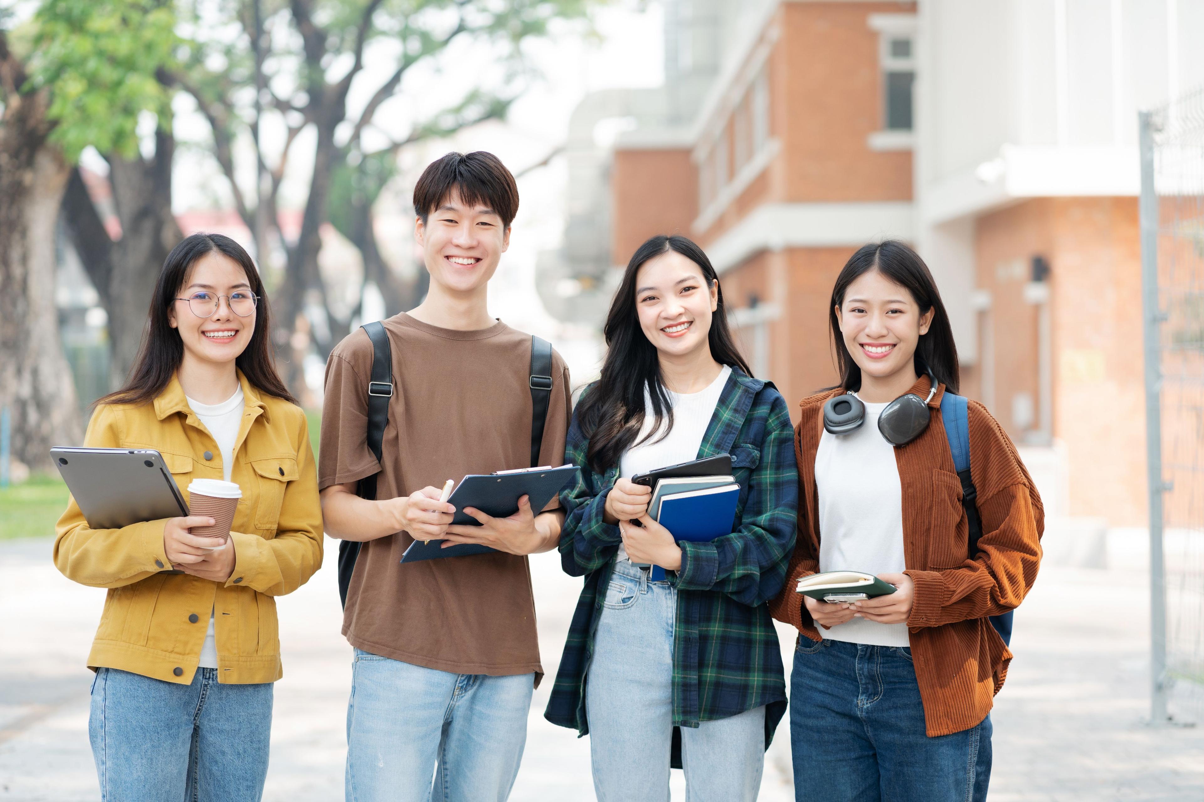 Group of happy students walking with notebooks at Politeknik Digital Indonesia
